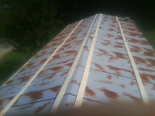 Rusted metal roof panels with new wood purlins before replacement — Storm Damage Roof Repair in Viola by Roofing Brothers